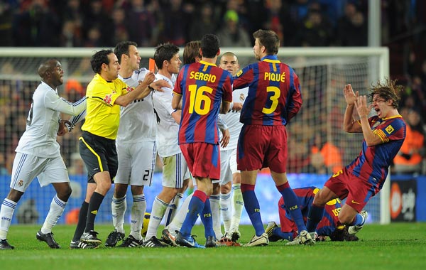 Barcelona's captain Carles Puyol (R) reacts after being pushed by Real Madrid's defender Sergio Ramos (hidden) during the Spanish league "clasico" football match FC Barcelona vs Real Madrid at Camp Nou stadium in Barcelona. Barcelona won 5-0. (AFP)