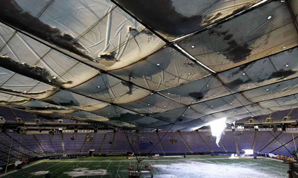 Snow falls into the field from a hole in the collapsed roof of the Metrodome in Minneapolis. The inflatable roof of the Metrodome collapsed Sunday after a snowstorm that dumped 17 inches (43 cms) on Minneapolis. No one was hurt, but the roof failure sent the NFL scrambling to find a new venue for the Vikings' game against the New York Giants. (AP)