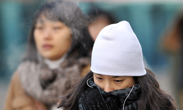 A South Korean woman covers her face with muffler as she walks on the street in Seoul. The temperature fell to minus 12.7 degrees Celsius in the capital as a cold weather warning was issued across the Korean peninsula. (AFP)