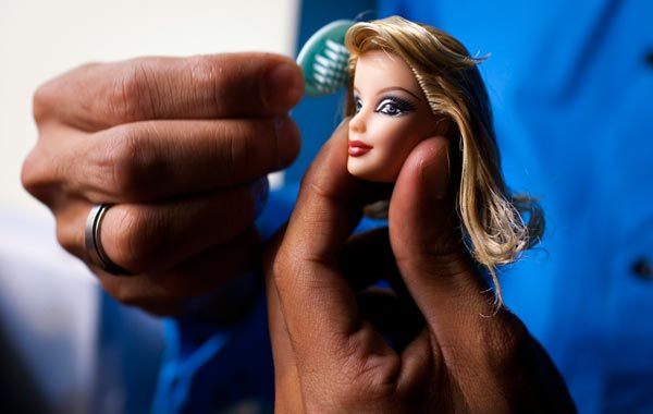 Contestant Yorlan Antillano combs the head of his Barbie doll "Rosalia Contreras Satag", entering the Miss Barbie Venezuela 2010 beauty pageant as "Miss Zulia" in Caracas. (REUTERS)