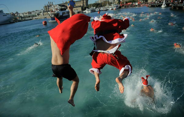 A competitor dressed up as Santa Claus jumps into the sea during the 101st Barcelona's Traditional Christmas Swimming Cup at the Old Harbour of Barcelona. (GETTY)