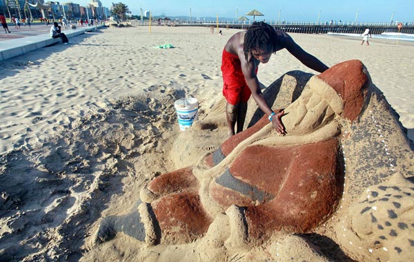 A sandsculptor prepares a Santa Claus sandcastle at Durban's North Beach. (AFP)