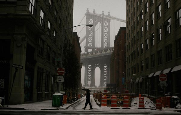 A man crosses a street near the Manhattan Bridge on the Brooklyn waterfront during a snowstorm. (AFP)