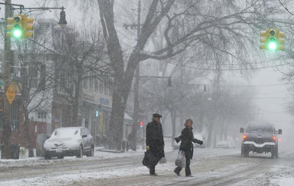 A couple cross the street during heavy snow in the Bronx borough of New York. The blizzard that has swept up the east coast is expected to bring 15-20 inches to the New York City area. (AFP)