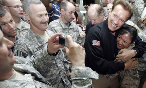 California Governor Arnold Schwarzenegger hugs a US soldier as they pose for a picture at US Camp Victory in Baghdad. (REUTERS)