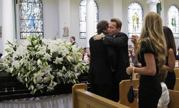 California Governor Arnold Schwarzenegger hugs entertainer Merv Griffin's son, Tony, during funeral services for Griffin in Beverly Hills, California. (REUTERS)