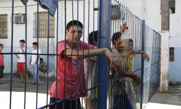 Inmates stand near a fence inside the Tacumbu high security prison in Asuncion. (REUTERS)