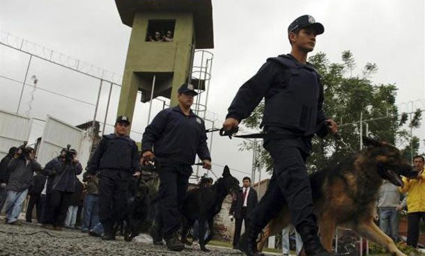 Police with dogs arrive at the Tacumbu prison as prisoners held hostages inside during an uprising for better conditions in Asuncion. (REUTERS)