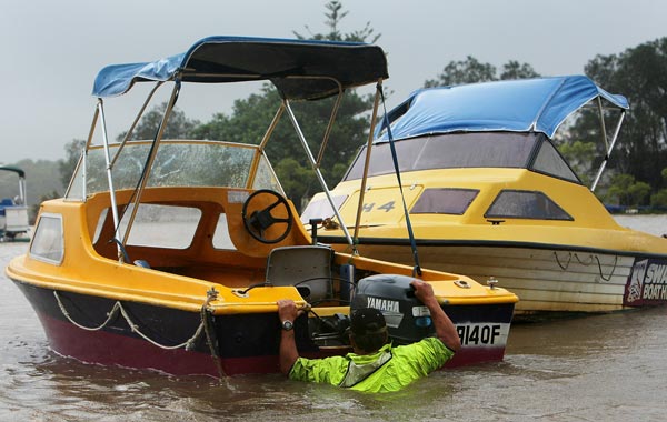 A man secures his boat on the Maroochy River as high tides and flood water cause it to rise on the  Sunshine Coast, Australia. 9 people so far have been confirmed dead in towns in the Lockyer Valley and over 70 are still reported missing after devastating floods inundated the region. (GETTY)