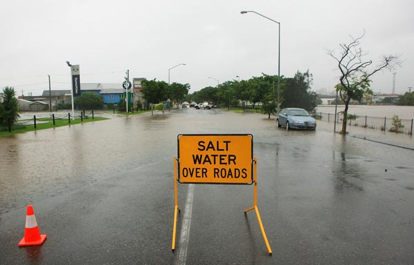 A sign warns people of flood waters over a suburban stree. (GETTY)