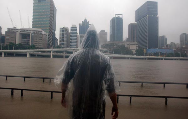 A man looks at the rising Brisbane River in central Brisbane. Thousands of  people were urged to leave the outskirts of Australia's  third-largest city, Brisbane. (REUTERS)