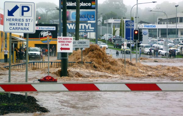 Water Street being submerged by flash floods described as an "inland tsunami" smashing through mountainside Toowoomba, sweeping away entire houses. (AFP)