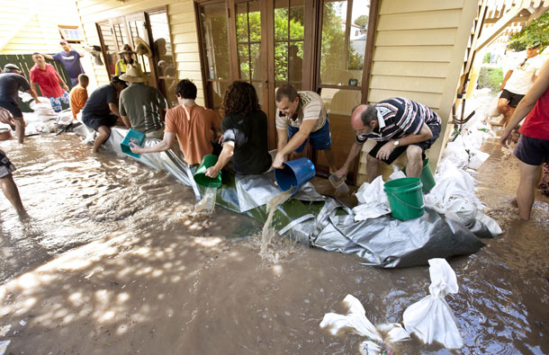 Friends pitch in to save local resident Paul O'Leary's home in the Bulimba suburb of Brisbane after flooding. Australia's third-largest city Brisbane was turned into a "war zone" on January 13 with whole suburbs under water and infrastructure smashed as the worst flood in decades hit 30,000 properties. (AFP)