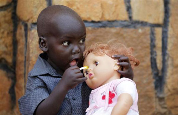 A child plays with his doll outside the St. Teresa's church in Juba, south Sudan. (REUTERS)