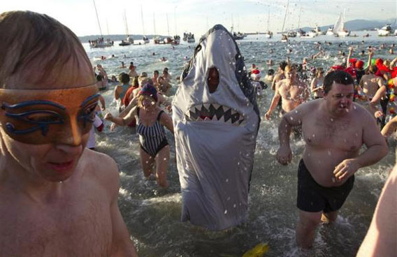 A participants dressed in a shark costume runs from the cold waters of English Bay while taking part in the 91st Polar Bear Swim in Vancouver, British Columbia. (REUTERS)