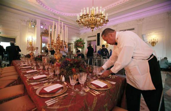 A White House kitchen staffer sets the main table during a press preview of the table settings for the state dinner hosted by President Obama for Chinese President Hu Jintao at the White House. (REUTERS)