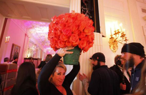 A White House staffer carries a vase of roses above her head during preparations for the state dinner hosted by President Obama for Chinese President Hu Jintao at the White House. (REUTERS)