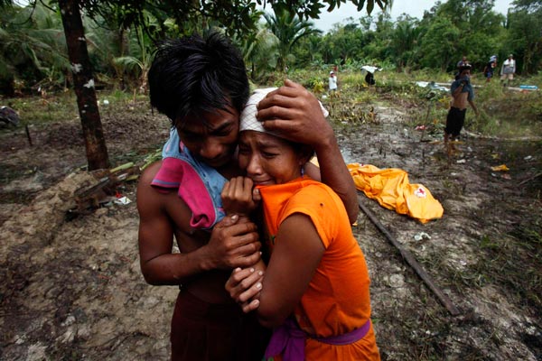 Survivors Markus (L) and his sister Lisna cry after finding their mother's body in the tsunami devastated Monte village, North Pagai island part of Mentawai islands, West Sumatra Indonesia. (EPA)