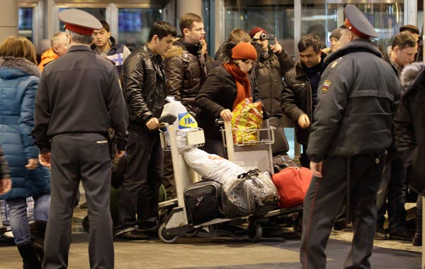 Police officers watch passengers at Domodedovo airport in Moscow, Monday, Jan. 24, 2011.  An explosion ripped through the arrivals hall at Moscow's busiest airport. (AP)