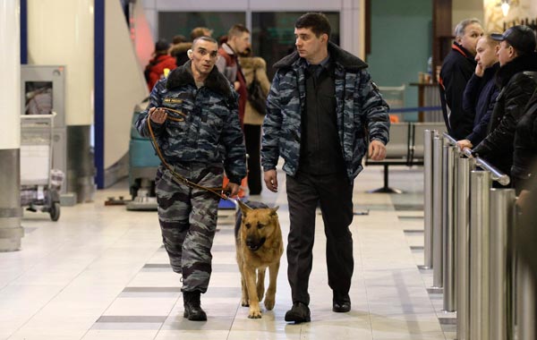 Police officers with a sniffer dog walk after an explosion at Domodedovo airport in Moscow. (AP)