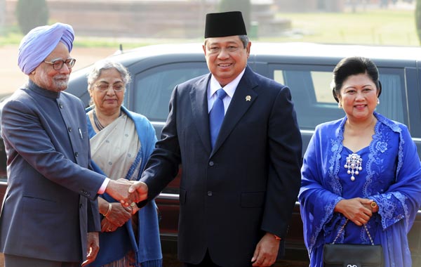 Indonesian President Susilo Bambang Yudhoyono (2R) shakes hand with Indian Prime Minister Manmohan Singh (L) as their wives Ani Bambang Yudhoyono (R) and Gursharan Kaur (2L) look on during a welcoming ceremony at the Presidential Palace in New Delhi. (AFP)