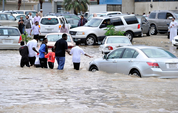 People walk along a flooded street after heavy rainfall in Jeddah. Torrential rainfall submerged streets and cut off electricity in parts of Saudi Arabia's second largest city Jeddah on Wednesday, raising fears of a repeat of floods in 2009 which killed more than 120 people. (REUTERS)