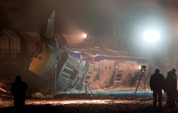 Bodies of casualties sit in front of overturned trains after a train crash in Hordorf near Oschersleben, eastern Germany. (AP)