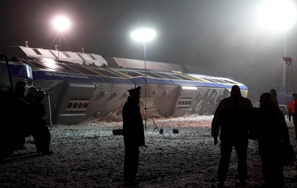 Rescue workers stands beside a overturned train after a train crash in Hordorf near Oschersleben, eastern Germany. (AP)