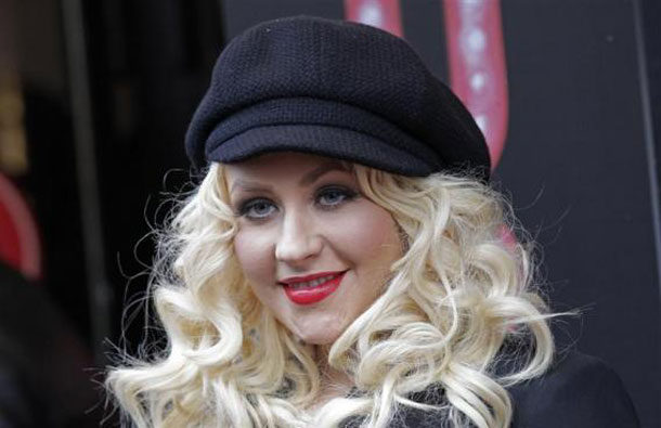 Cast member Christina Aguilera poses in front of the Crazy Horse cabaret during the photocall of the movie "Burlesque" in Paris. (REUTERS)