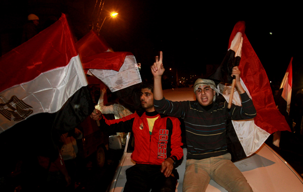 Palestinians in a passing car wave Egyptian flags in celebration after receiving the news of Egyptian President Hosni Mubarak's resignation, as Hamas called for celebrations in Gaza City. (AP)