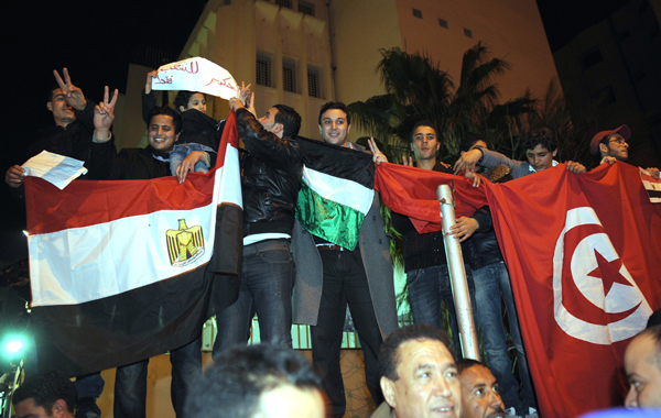 Tunisian people celebrate in front of the Egyptian embassy after Egyptian President Hosni Mubarak ceded power to a junta of senior military commanders in Tunis. (AFP)