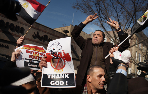 People in a neighborhood with a large Egyptian diaspora celebrate in the street following the news that Hosni Mubarak stepped down. (AFP)