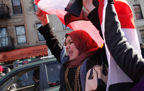 Egyptians in a neighborhood with a large Egyptian diaspora celebrate in the street following the news that Hosni Mubarak stepped down. (AFP)