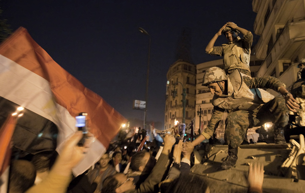 Egyptian soldiers celebrate with anti-government protesters at Cairo's Tahrir Square after president Hosni Mubarak stepped down. (AFP)