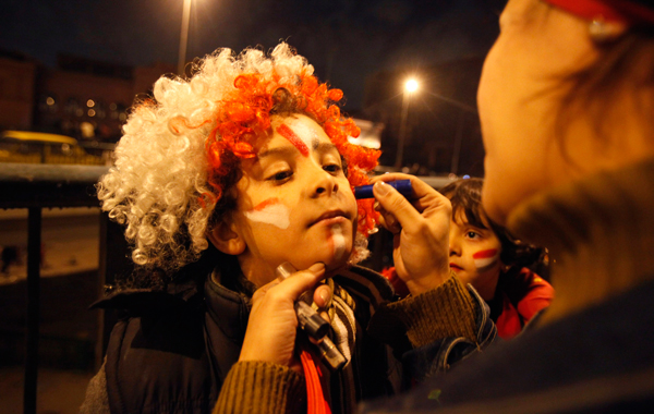 A woman draws the colours of the Egyptian flag on her child's face with her make-up as people celebrate in Cairo's Tahrir Square, after Egypt's President Hosni Mubarak resigned. (REUTERS)