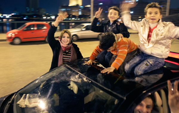 Egyptians hang out on their cars as they celebrate the resignation of Egyptian President Hosni Mubarak in downtown Cairo. (AP)