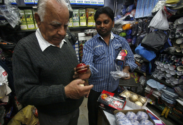 A customer (L) buys a cricket ball at a shop in the old quarters of Delhi February 4, 2011. Picture taken February 4, 2011. (REUTERS)