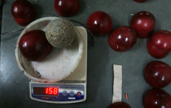 A string-wrapped spherical core and two leather halves are weighed before they are made into a cricket ball at a factory in Meerut, 80 km (50 miles) northeast of Delhi. (REUTERS)