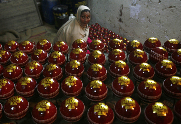 A worker shines cricket balls before packing them at a factory in Meerut, 80 km (50 miles) northeast of Delh. (REUTERS)