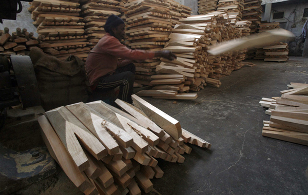 A worker carves pieces of willow to make cricket bats at a factory in Meerut, 80 km (50 miles) northeast of Delhi. (REUTERS)