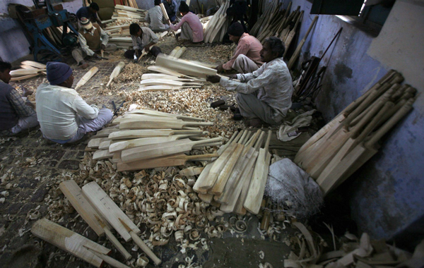 Workers file the edges of cricket bats to a smooth finish and fit cane sticks onto the handles at a factory in Meerut, 80 km (50 miles) northeast of Delhi. (REUTERS)