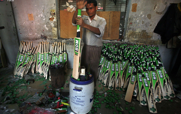 A worker adjusts the grip on the handle of a cricket bat at a factory in Meerut, 80 km (50 miles) northeast of Delhi. (REUTERS)