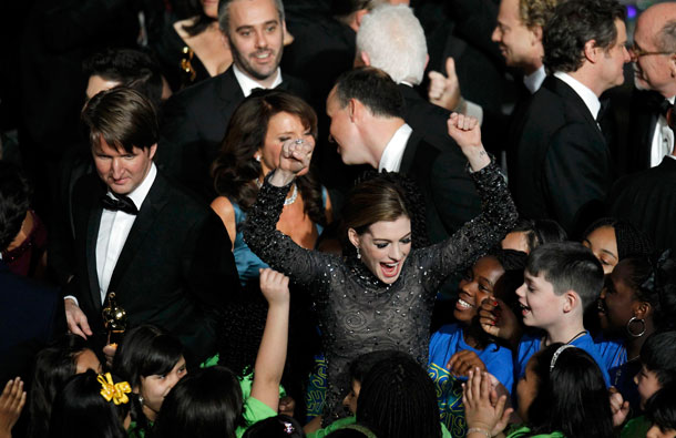 Host Anne Hathaway (C) dances with students from Public School 22 chorus from Staten Island, New York during the finale of the 83rd Academy Awards, as best director Oscar winner Tom Hooper (L) looks on, in Hollywood, California. (REUTERS)