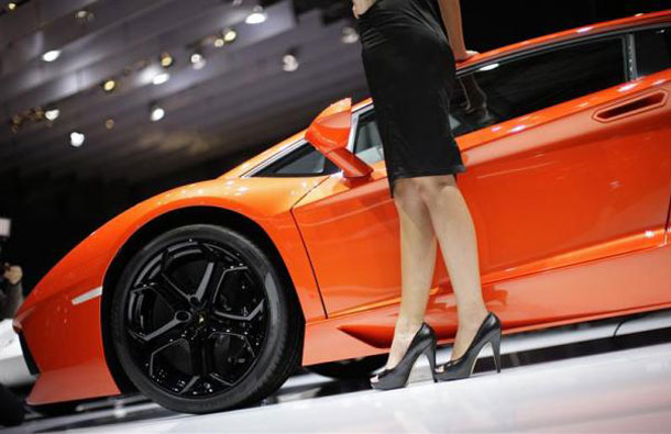 A model poses besides a Lamborghini car at the company's showcase during the first media day of the 81st Geneva International Motor Show at the Palexpo in Geneva March 1, 2011. (REUTERS)