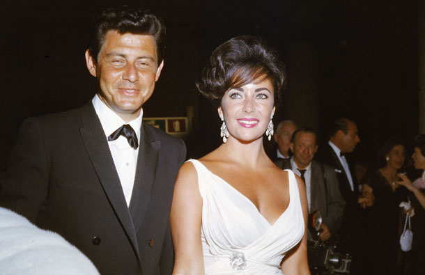 British born actor Elizabeth Taylor and her fourth husband American singer and actor Eddie Fisher arrive at a formal event, c. 1962. (GALLO/GETTY)