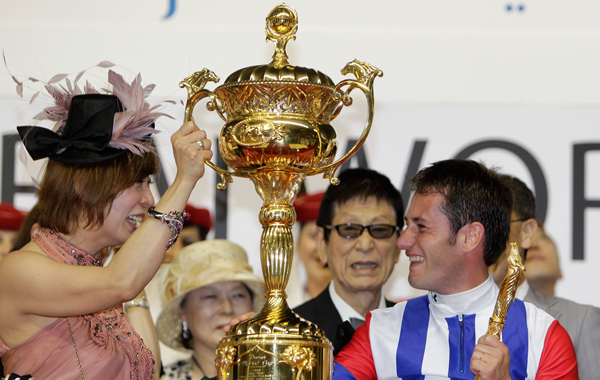 Mirco Demuro, the jockey of Victorie Pisa from Japan, right ,celebrates after he won the $10,000,000 Dubai World Cup at the Meydan in Dubai, United Arab Emirates. (AP)