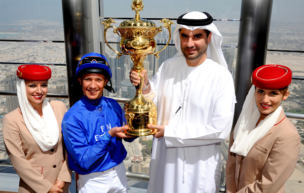 In this photo taken on Tuesday March 15, 2011 and made available by Meydan City Corporation, three-time Dubai World Cup winning jockey Frankie Detorri, 2nd left, holds the world's richest horse race, Dubai World Cup's trophy, with Senior Vice President, Commercial Operations of Emirates Airlines, Ahmed Khoory, 2nd right, on top of the world's tallest building, Burj Khalifa in Dubai, United Arab Emirates. (AP)