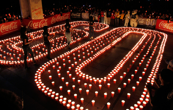 Women walk through an arrangement of candles that form the number 60, to represent the minutes in an hour, during a candlelight vigil marking “Earth Hour” at La Plaza del Bicentenario in La Paz, Bolivia. (AP)