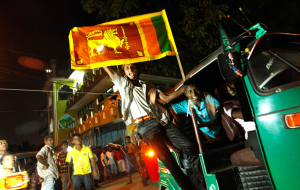 Sri Lankan cricket fans parade in their neighborhood carrying national flags in support of their team to win the Cricket World Cup final match against India on the eve of final match in Colombo, Sri Lanka. (AP)