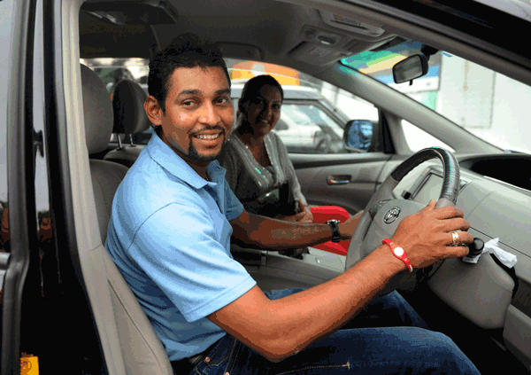 New captain of the Sri Lanka cricket team Tillakaratne Dilshan (left) and his actress wife Manjula Thilini sit in a car outside the governing body's office in Colombo on Wednesday. (AFP)
